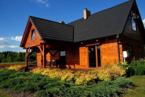 RedułtyUroczy drewniany dom w ciszy i spokoju的大型小木屋,设有黑色屋顶