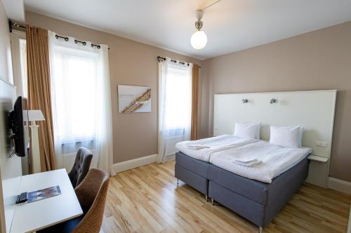 厄勒布鲁亚尔马酒店的卧室配有一张床和一张桌子及椅子