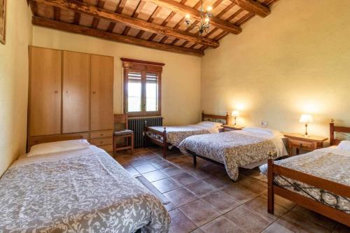 赫罗纳Can Salvà Casa rural en magnífico entorno natural的带三张床和窗户的客房