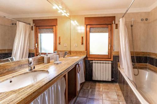 赫罗纳Can Salvà Casa rural en magnífico entorno natural的带浴缸、两个水槽和浴缸的浴室