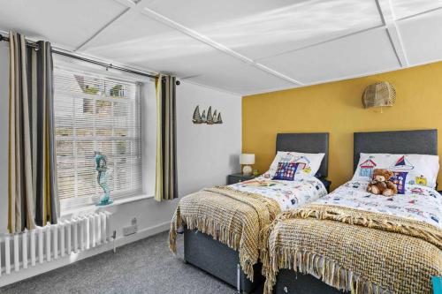 布里克瑟姆Family Tides Brixham的一间卧室设有两张床和窗户。