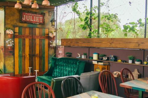 圣安娜Velvet Hostal La novena的餐厅设有绿色长凳和桌椅