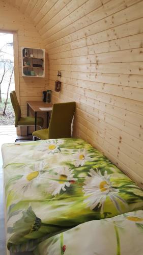 诺尔德霍尔茨Glamping Pod im Wald mit Einzelbetten的一张床上的鲜花盛开的睡床