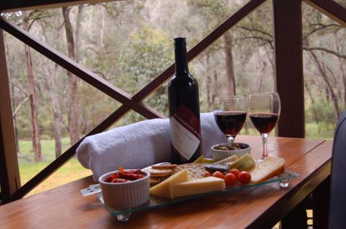 楠立比阳德拉普瀑布成人休闲酒店的一瓶葡萄酒和一盘奶酪及酒杯