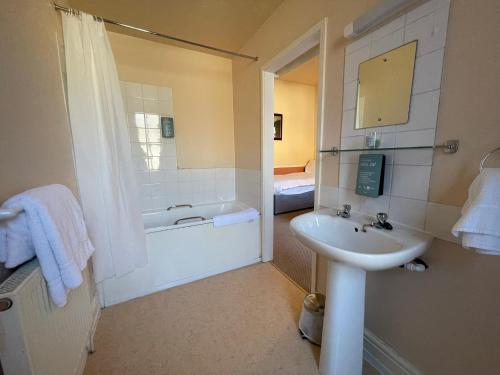 巴茅思The Sandbanks的浴室配有盥洗盆和浴缸。