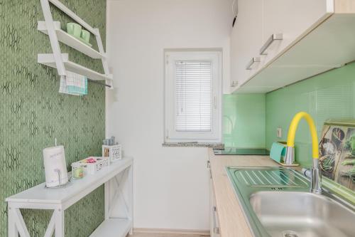 克尔克Apartment Stella di Mare的厨房设有水槽和绿色的墙壁