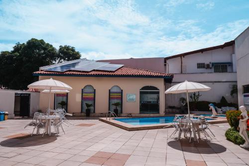 圣路易斯Costa Atlantico Hotel的游泳池旁带椅子和遮阳伞的天井