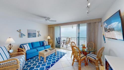 马可岛Beachfront 1 Bed w/ On Site Tiki Bar/Restaurant!的客厅配有蓝色的沙发和桌子