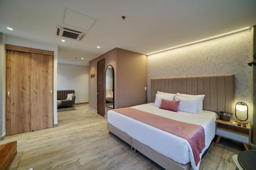 麦德林Eutopiq Hotel的一间带大床的卧室和一间客厅
