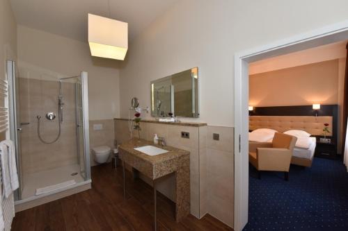什未林文豪斯沃勒酒店的一间带水槽和淋浴的浴室以及一张床