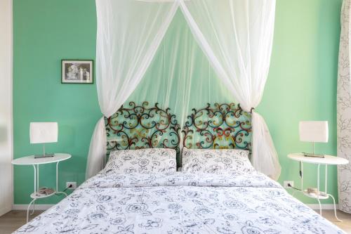 陶尔米纳Tauromenion Guest House的一间卧室配有一张带天蓬和两盏灯的床。