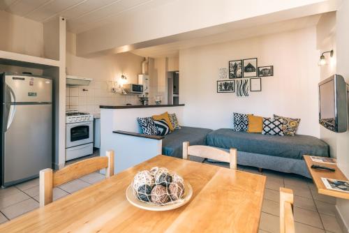 乌斯怀亚维归纳海滨公寓的厨房以及带桌子和沙发的客厅。