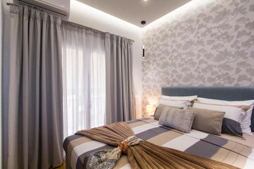 雅典Luxurious apt near Ampelokipoi Metro station的一间卧室设有一张大床和大窗户
