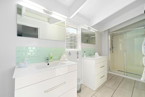 陶波Botanical HideAway Taupo的白色的浴室设有水槽和淋浴。