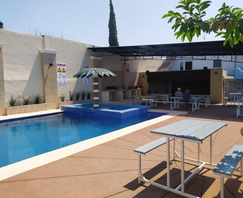 马塔莫罗斯Hotel POSADA DEL REY的一个带桌子的游泳池和一个庭院
