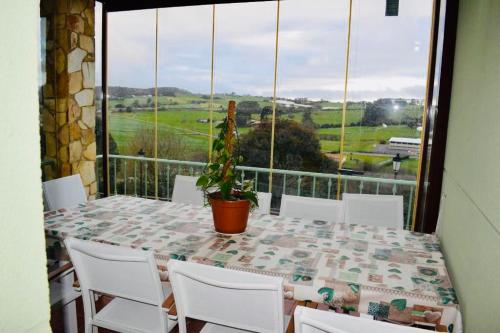 康达Casa Villa Mey的阳台上配有一张桌子、白色椅子和盆栽植物