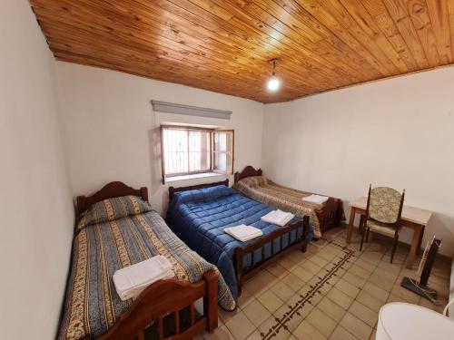 乌尼翁镇Mis Marias的一间卧室设有两张床、一张桌子和一个窗口