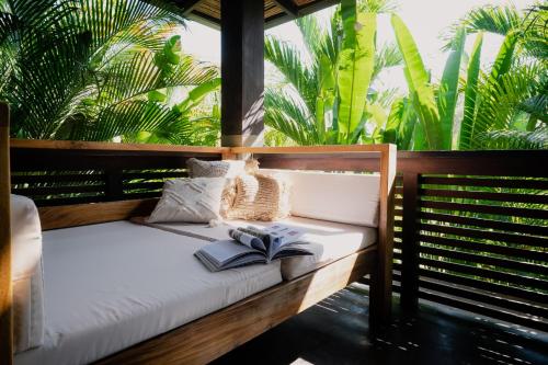 圣塔特蕾莎海滩Lua Villas的一张床上有两本书,上面有棕榈树