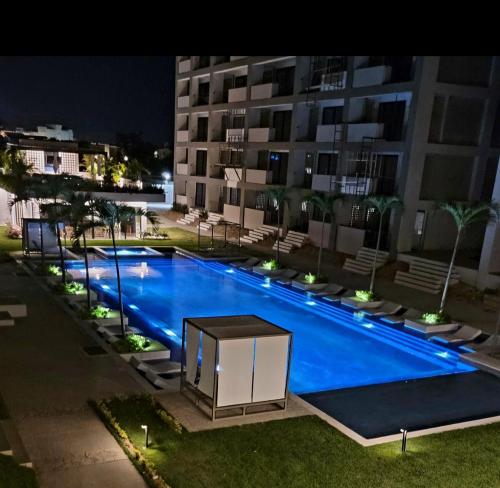 新巴利亚塔IYARI 2 bdr Apartment的大楼前的大型蓝色游泳池
