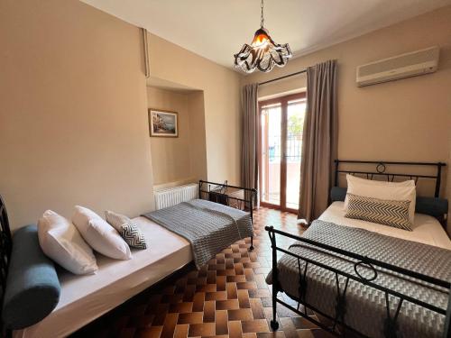 瓦西Antonios House Ithaka的一间卧室配有两张床和吊灯。