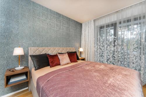 伏尔塔瓦河畔利普诺Apartament A121 Molo Lipno s infrasaunou - Residence Koubek的一间卧室设有一张大床和一个窗户。