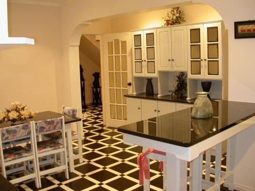 马达莱纳Moradia Familiar NovaVista - T3的厨房铺有黑白色瓷砖地板。
