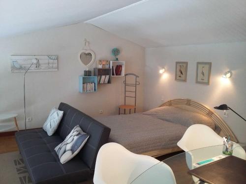 圣马丹德雷Appartement Saint-Martin-de-Ré, 3 pièces, 4 personnes - FR-1-544-10的一间卧室配有一张床、一张沙发和椅子