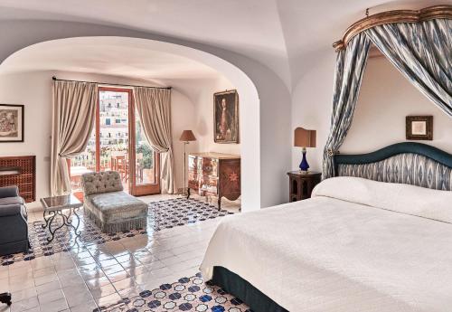 波西塔诺勒西雷纳斯酒店的一间卧室配有一张特大号床和一个壁炉