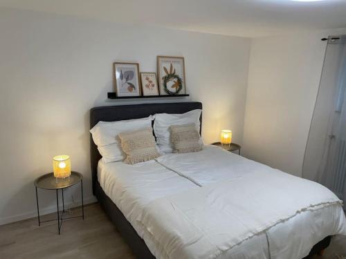 博伦多夫Gemütliche&Moderne Ferienwohnung Nähe Trier & Luxemburg的一间卧室配有一张带两张桌子和蜡烛的床。
