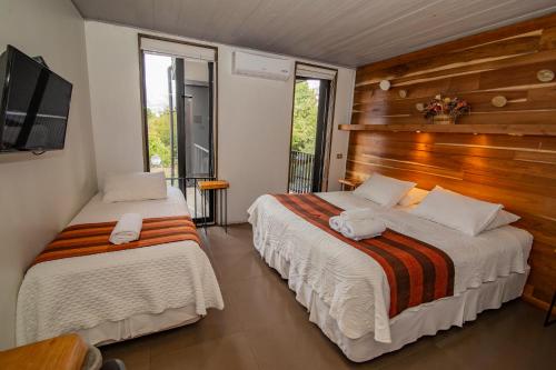 普孔Hotel Cumbres del Sur的一间卧室配有两张床和一台平面电视