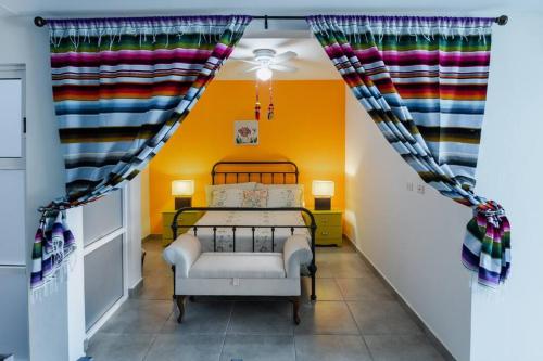 埃尔普埃夫利托CASA ZARAPE, 3BR, 2BT, 6 PAX.的卧室配有一张床铺,位于一个黄色墙壁的房间