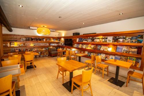 普孔Hotel Cumbres del Sur的图书馆内带桌椅的餐厅