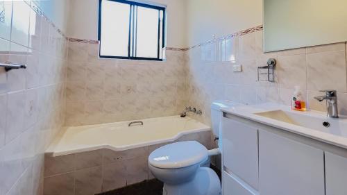 悉尼Carlton 3 beds unit - free parking的浴室配有卫生间、浴缸和水槽。
