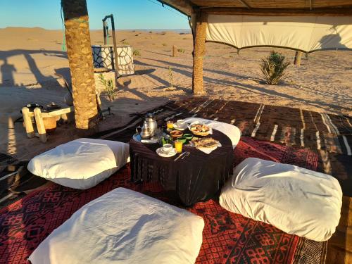 姆哈米德比沃亚克拉杜恩布兰奇酒店的一张桌子,上面有食物和饮料,在沙漠里