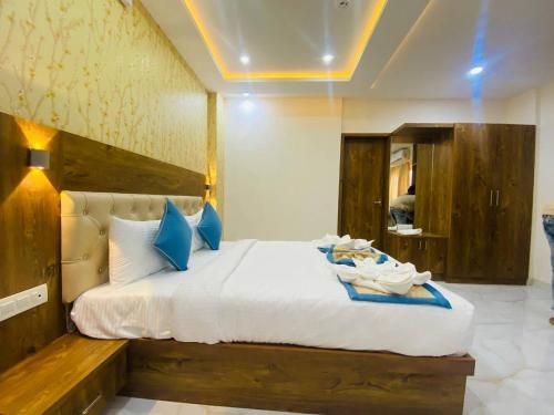 班加罗尔Spectra Hotel Bangalore Airport的卧室配有带蓝色枕头的大型白色床