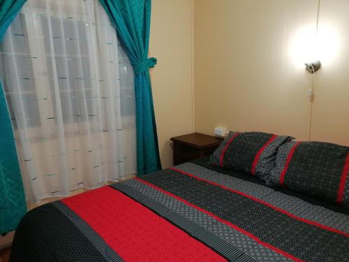 金特罗Cabaña "Descanso playero"的一间卧室配有一张带红色和黑色毯子的床