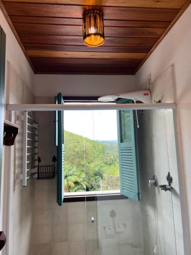 新文达移民镇Pousada na Cervejaria Altezza的带淋浴、窗户和玻璃淋浴的浴室