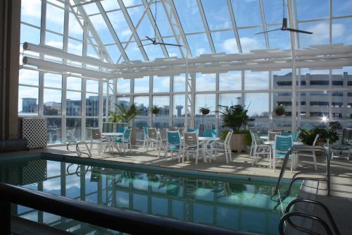 弗吉尼亚海滩弗尔赛欧度假酒店的大楼内一个带桌椅的游泳池