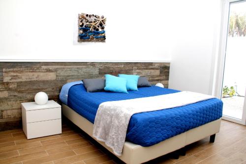 托雷拉皮罗Altomare Case Vacanza的一间卧室配有一张带蓝色枕头的大床