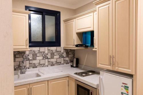 塔伊夫بيوتات الحور的厨房配有白色橱柜和水槽