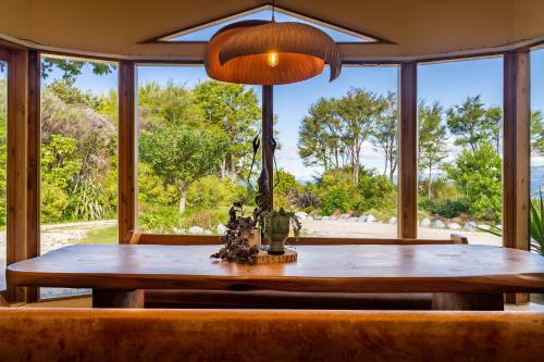科灵伍德Ao Marama Retreat的餐桌、椅子和大窗户