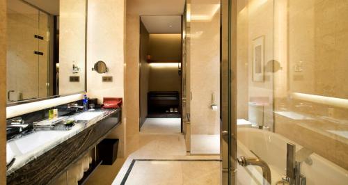 天津天津京基皇冠假日酒店的浴室配有2个盥洗盆、浴缸和淋浴。
