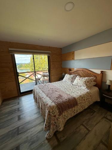 卡斯特鲁Cabañas Terra Palafito的一间卧室设有一张床和一个大窗户