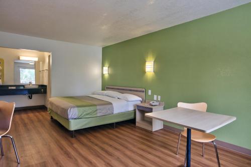 塔拉哈西塔拉哈西市中心6号汽车旅馆的配有一张床和一张桌子及椅子的房间