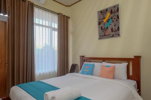 日惹Sans Hotel Kumbang Yogyakarta by RedDoorz的一间卧室设有两张床和窗户。