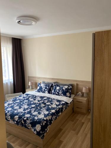 布尔加斯Luxury family apartament的一间卧室配有一张带蓝色花卉床罩的床。