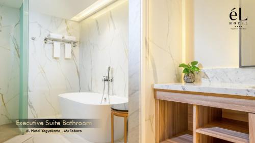日惹eL Hotel Yogyakarta Malioboro的浴室配有白色水槽和浴缸。