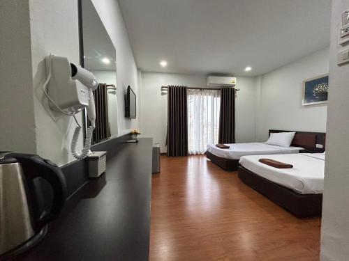乌汶Bordin Hotel的一间酒店客房,设有两张床和电视