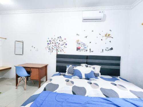 泗水Homey Guesthouse Kertajaya (Syariah)的一间卧室配有一张床、一张桌子和一张书桌
