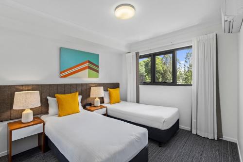 布里斯班Quest Kelvin Grove的酒店客房设有两张床和两盏灯。